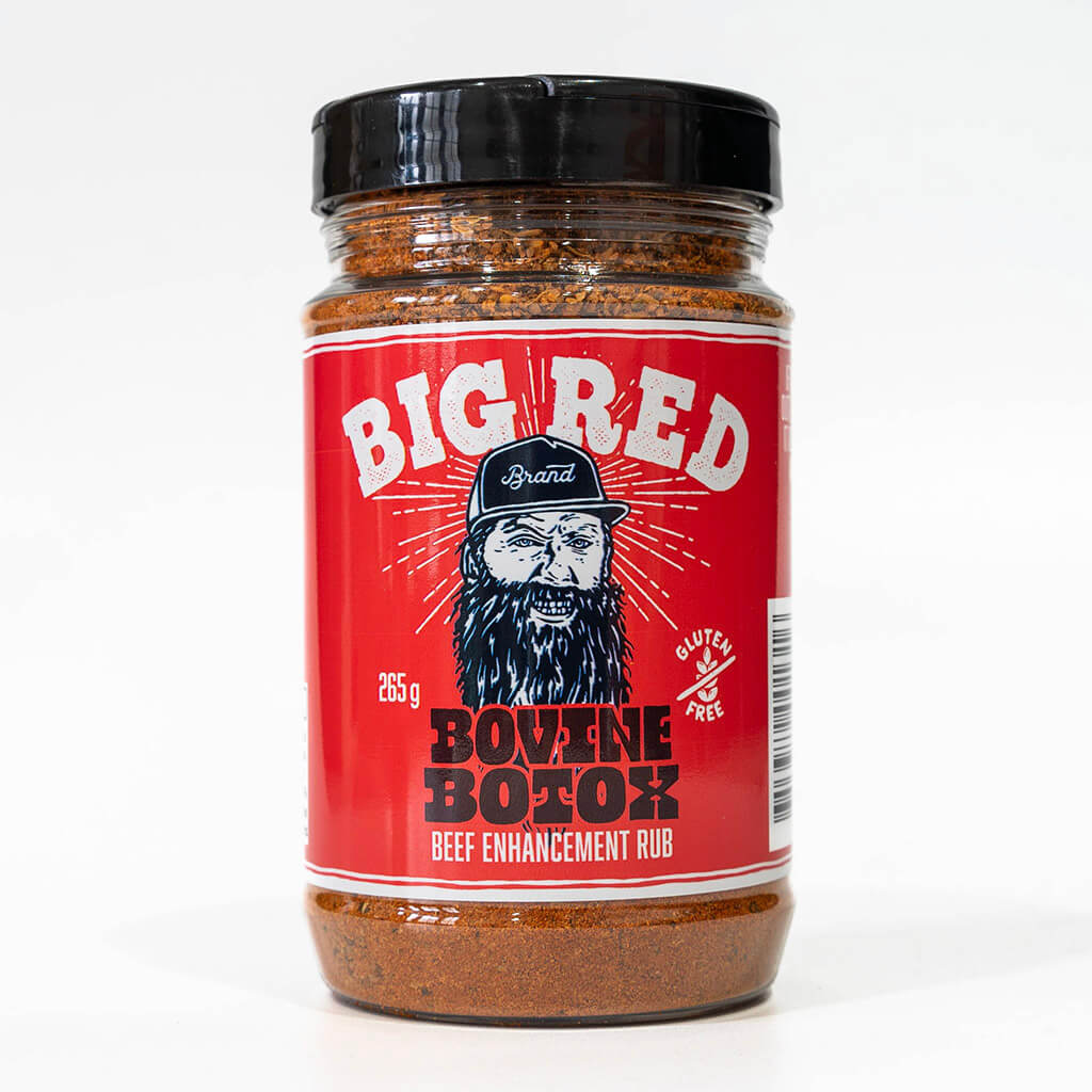 Close-up image of 'BIG RED Brand' jar with a bearded man illustration, labeled 'Bovine Botox Beef Enhancement Rub' and 'Gluten-Free', 265g weight indication on a red background.