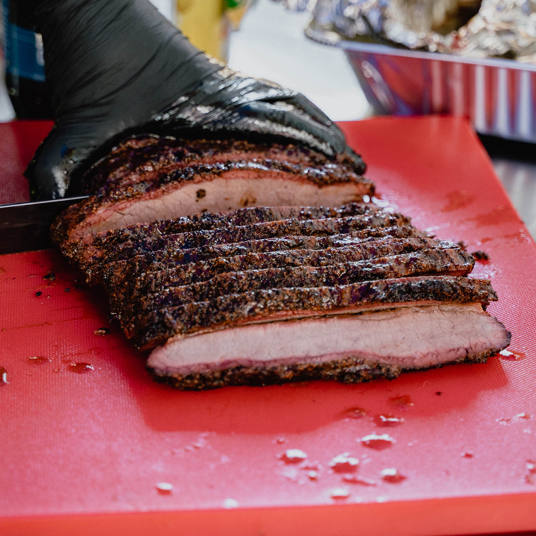 A close-up image of a slicing knife cutting through a tender, juicy brisket that has been reheated to perfection.