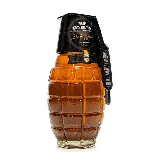 Close-up view of 'The General's Bold Gold' cayenne-infused extra virgin olive oil bottle, showcasing its unique grenade design and detailed label.