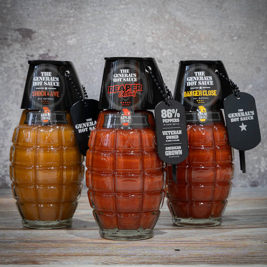 Three bottles of The General's Hot Sauce Thermal Strike set, featuring Reaper Actual, Shock & Awe, and Danger Close sauces with military grenade design and tags stating pepper content and heat levels.